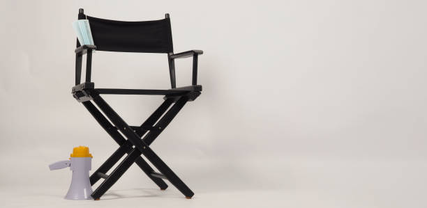 istock Black director chair and megaphone on the floor. It is white background. 1390677542