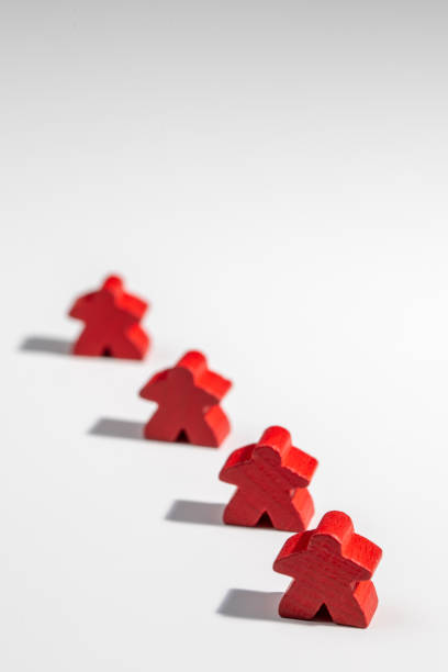 Red board game wooden figures standing as a team  with select focus blur stock photo