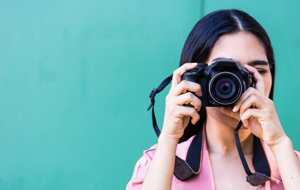 istock woman holding a camera taking a photo front camera. 1390679541