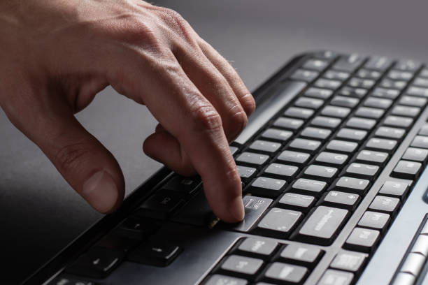 istock Finger presses the enter button. Typing male hands. Black keyboard button close up 1390680435
