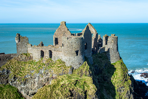 Dunluce Castle ruins at Northern Ireland with blue sea background in a sunny day.