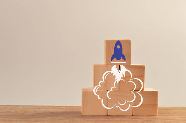istock Wooden cube blocks with launching rocket. Business start up, new idea and new project concept 1390680843