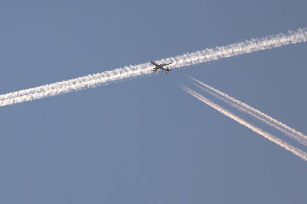 istock Ariplane crossing condensation trail. 1390682066