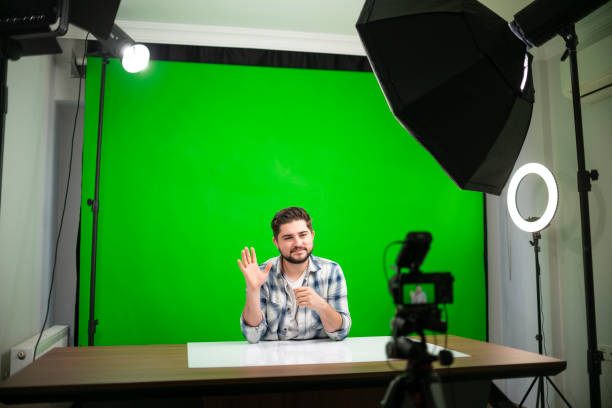 jovem bonitão vlogging em um estúdio contra fundo verde - chroma key fotos - fotografias e filmes do acervo