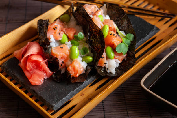 Trendy Hybrid Food Sushi Tacos with salmon, rice and edamame beans. Trendy Hybrid Food Sushi Tacos with salmon, rice and edamame beans. nori stock pictures, royalty-free photos & images