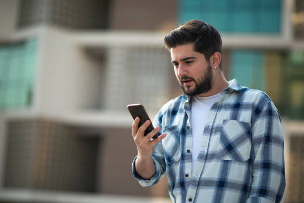 Upset man looking at his mobile phone stock photo