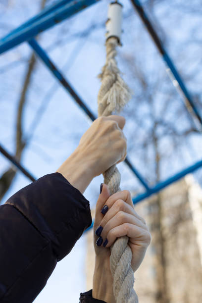 istock woman's hand holding onto a vertical rope 1390685353