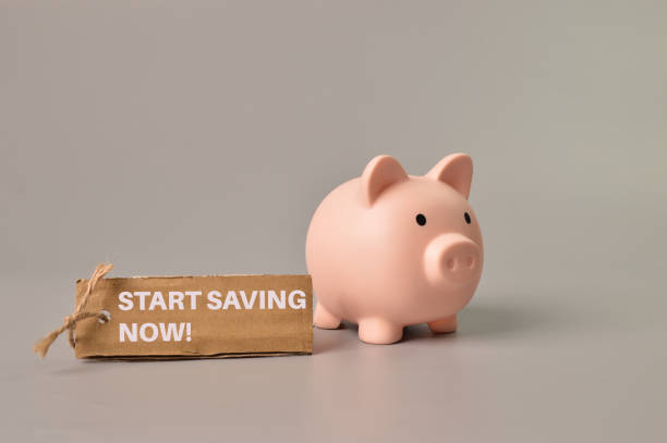 istock Piggy bank and label tag written with START SAVING NOW! 1390686148