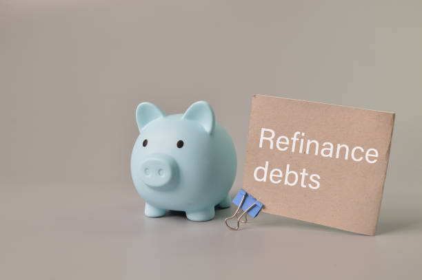istock Piggy bank and memo note written with REFINANCE DEBTS. 1390686308
