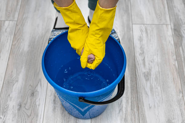 istock a man in rubber gloves wringing out a rag in a bucket 1390686986