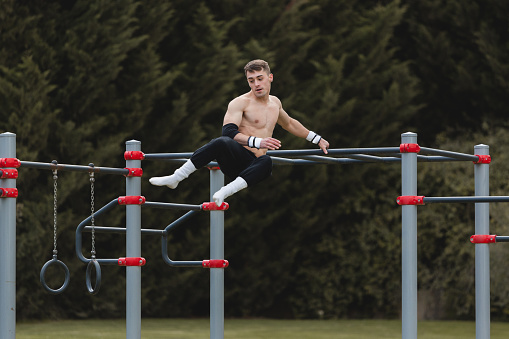 Young man practicing calisthenics outdoor. Sport lifestyle concept.