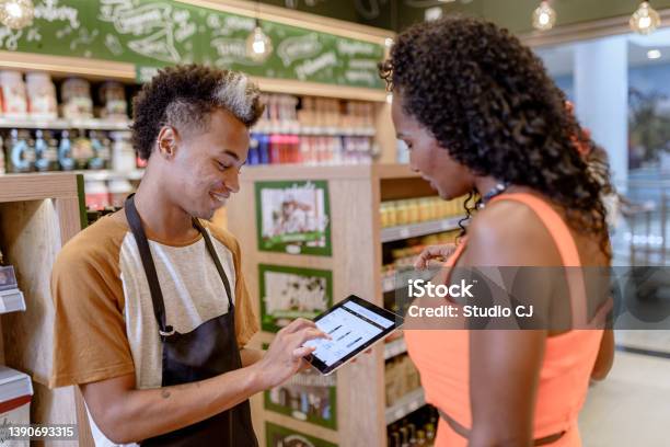 Salesperson Presenting Products In The Stores Ecommerce Using Digital Tablet Stock Photo - Download Image Now