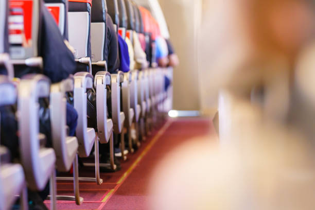 飛行機エコノミークラスの座席列に座っている乗客の背面図のクローズアップ。 - commercial airplane airplane cabin passenger ストックフォトと画像