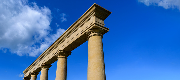 Fragment of a classical building with columns on a background of the blue sky with copy space