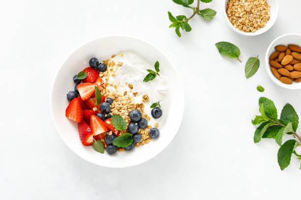 Breakfast bowl with granola, plain yogurt, strawberry and blueberry, top view