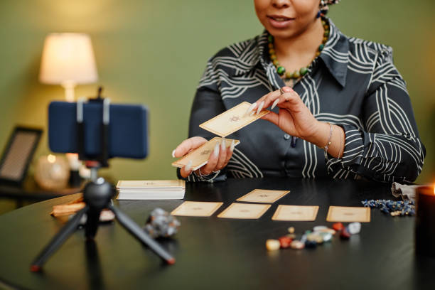 Online Fortune Telling Seance Close up black young woman doing tarot reading on camera and recording video with smartphone Psychic Medium online stock pictures, royalty-free photos & images