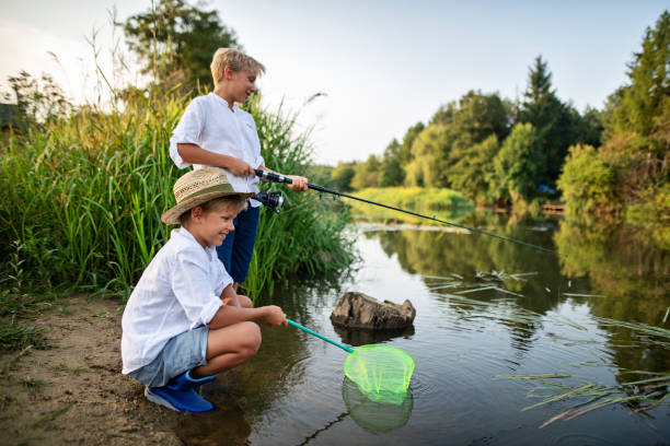istock Little boy fishing in river 1390703317