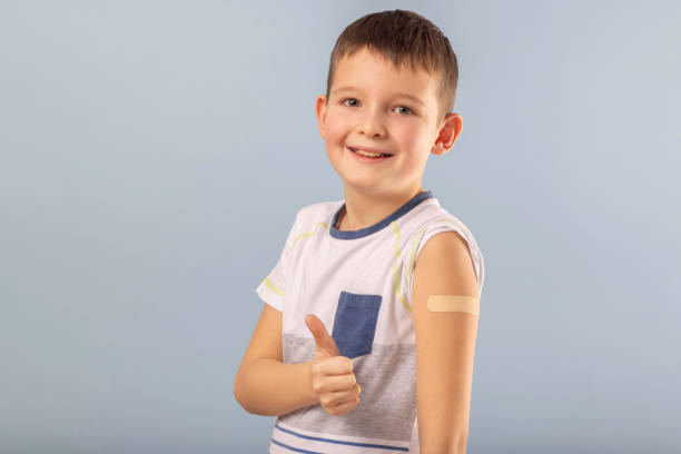 istock Vaccinated boy gesturing with thumbs up, showing hand with plaster cast after injection of coronavirus vaccine. Start of vaccination campaign for children and teenagers. Successful Covid-19 vaccination 1390705877