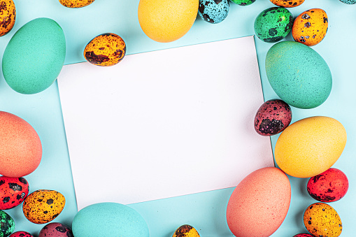 Stylish background with colorful easter eggs isolated on pastel blue background with copy space. Flat lay, top view, mockup, overhead, template. High quality photo