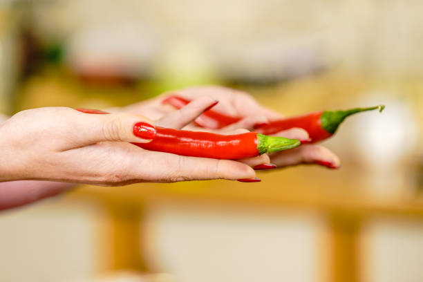 Unrecognizable woman holding red chilli hot pepper paprika. Spicy food, oriental seasonings concept.