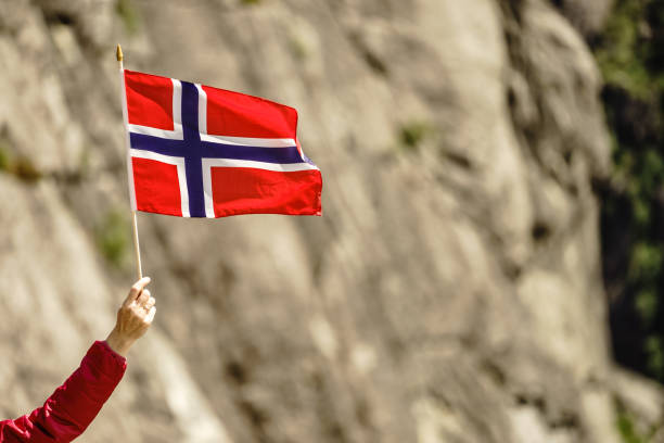 istock Tourist with norwegian flag in rocks mountains 1390708019