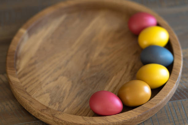 six painted Easter eggs lie on a wooden background with space for text. High quality photo