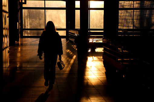 Silhouette of a girl walking alone through the hallway