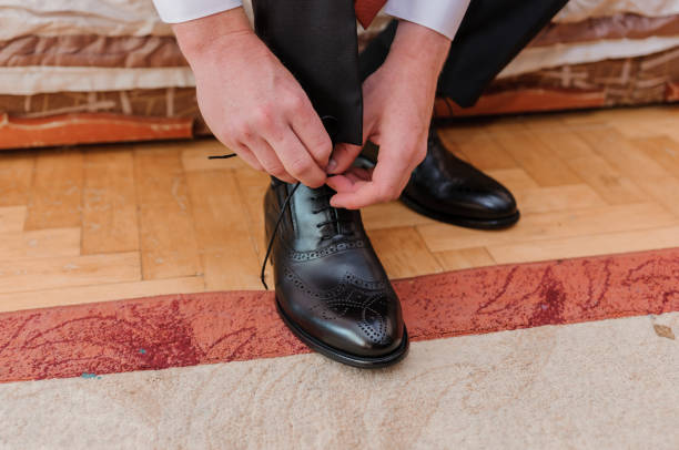 istock Man tying shoelaces on black leather shoes 1390708432