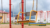 old brown yellow swing in local playground with attractions