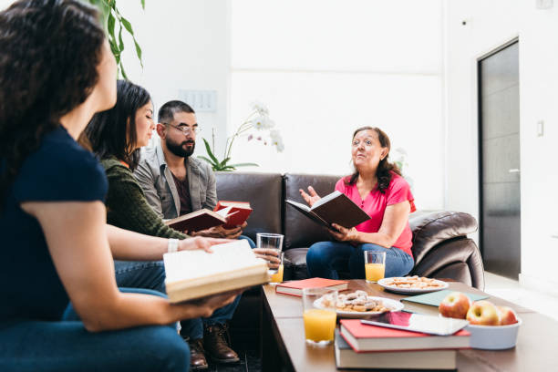 istock Book club host reading to the group 1390710586