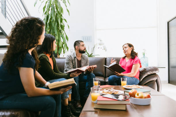 istock Book club host reading to the group 1390711633