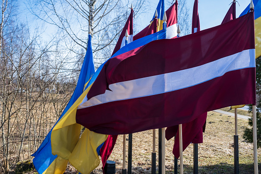 Flags of Ukraine and Latvia. Protest against war and global military conflict, invasion in Riga, Europe