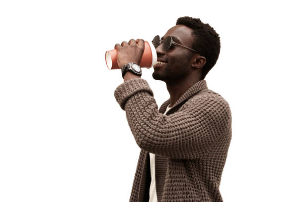 Portrait of happy young african man drinking coffee isolated on white background stock photo