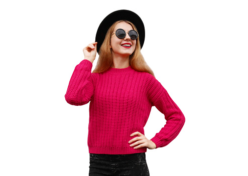 Portrait of happy smiling young woman model wearing pink knitted sweater and black round hat isolated on white background