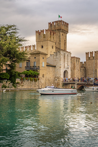 Sirmione, Garda Lake, Italy - August 12, 2019: Rocca Scaliger castle at Sirmione. Tourists enter into the center of the peninsula via the footbridge.