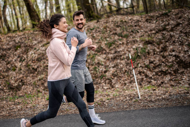istock Happy athletic couple having fun while running in spring day 1390714047