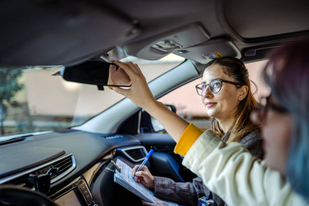 Teenager girl having driving lesson with female instructor stock photo