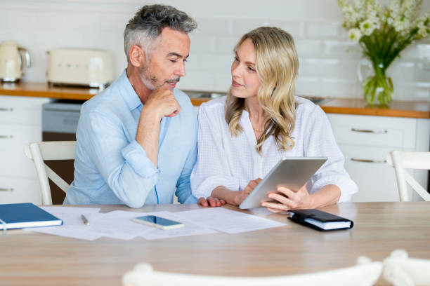 istock Mature couple doing paperwork and paying bills at home. 1390714456