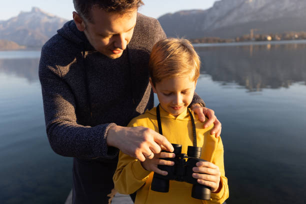 istock Father and son using binoculars for discover a mountain landscape 1390716784