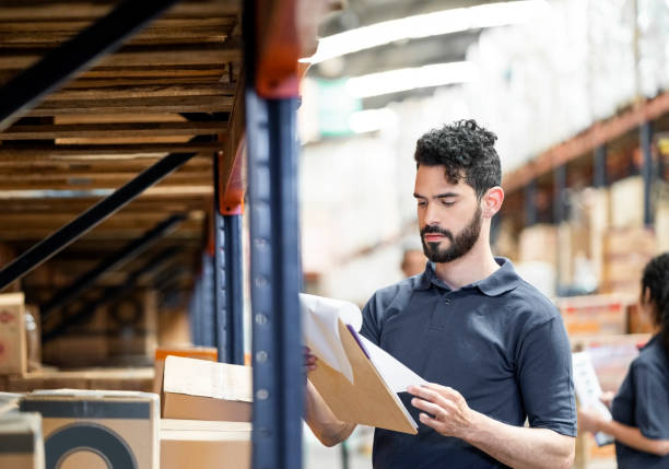 istock Warehouse worker checking stock levels on the storage rack 1390717519