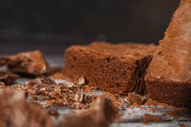 istock Chocolate brownies on a rustic wooden table with chocolate chips and chocolate soil next to the brownie portions.Close up. 1390717543