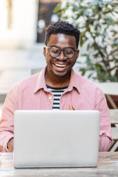 istock Smiling African-American man using laptop outside 1390721332