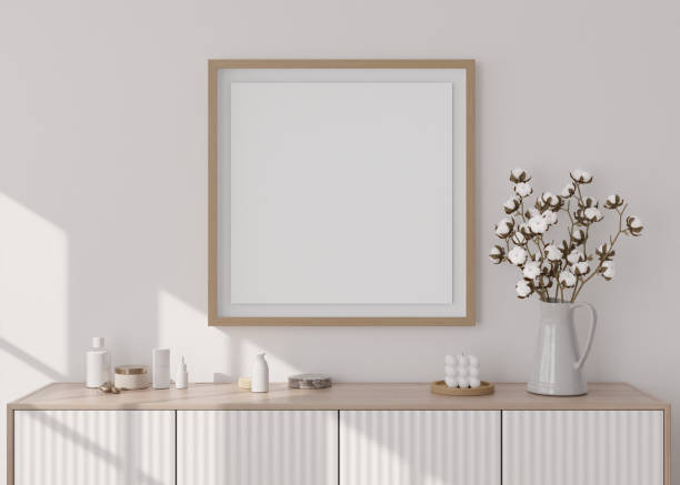 istock Empty square picture frame on white wall in modern living room. Mock up interior in minimalist, scandinavian style. Free, copy space for picture. Console, cotton plant, vase. 3D rendering. 1390722289