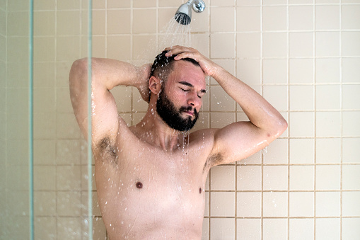 Photo of a man taking a shower.