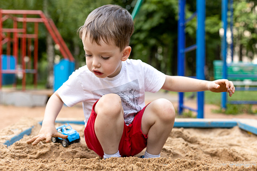 Outdoors portrait of a 4 year old boy playing on a playground