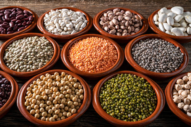 istock Assorted legumes in round clay containers on rustic wooden background 1390724669