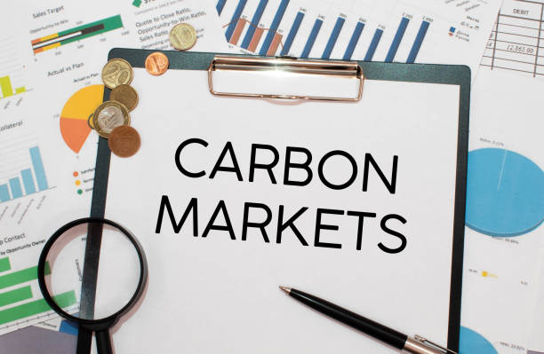 istock CARBON MARKETS. text on white paper near dollar bills. 1390725877