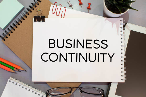 istock Stickers on notebook text BUSINESS CONTINUITY with pen and glasses on the white background 1390725878