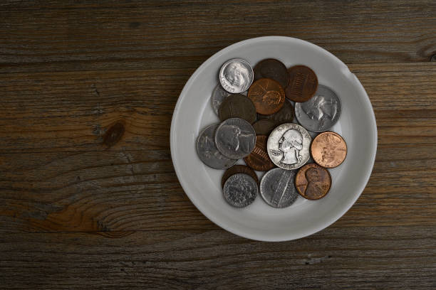 small American coins on a white porcelain saucer stock photo