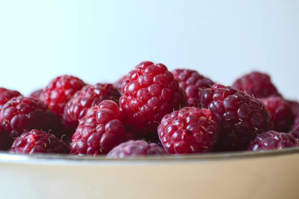 Close up of red raspberries in a porcelain bowl stock photo